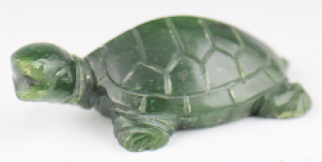CARVED SPINACH GREEN JADE TURTLE: CARVED SPINACH GREEN JADE TURTLE A carved spinach green turtle. Four feet and small tail are visible in addition to the head, which is cocked to the left. Simple geometric patterns cover the shell. Si