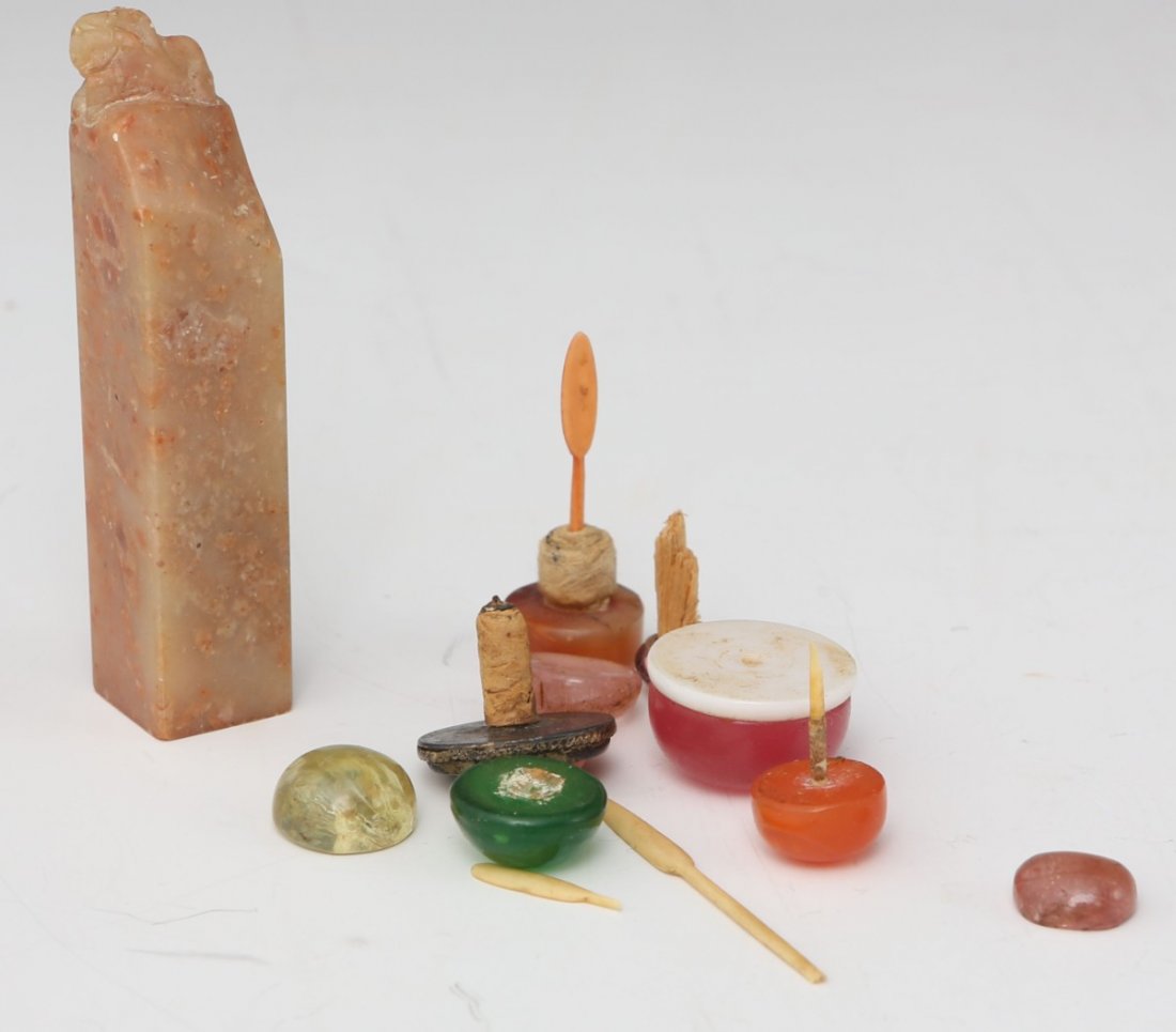 A CHINESE CHOP SEAL & SNUFF BOTTLE TOPS: A CHINESE CHOP SEAL & SNUFF BOTTLE TOPS Soapstone seal with a tiny carved foo dog finial, and 10 snuff bottle tops. Size: Chop is 3"
