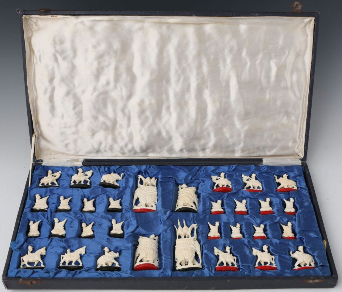 CARVED IVORY INDIAN CHESS SET: CARVED IVORY INDIAN CHESS SET A carved Ivory chess set of Indian motif. Red and black paint differentiate the two opponent pieces. King and Queen pieces are represented by elephants mounted by warrior