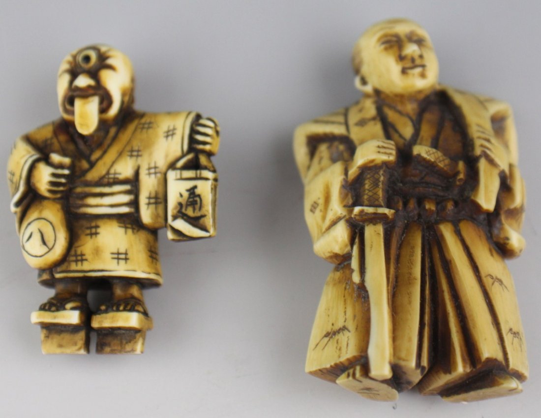 CARVED IVORY NETSUKE ONI WARRIOR SIGNED: CARVED IVORY NETSUKE ONI WARRIOR SIGNED Two carved ivory netsuke, a warrior and an oni figure. The warrior is armed with two blades and is clad in robes. The oni is a cyclops and is extending its tong
