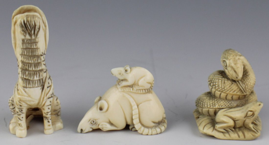 FOUR CARVED IVORY ANIMAL NETSUKE SIGNED: FOUR CARVED IVORY ANIMAL NETSUKE SIGNED Lot features 3 carved Japanese ivory netsuke in animal forms. To include a rat perched atop of a larger rat, a snake coiled beside a frog, and a howling foo dog