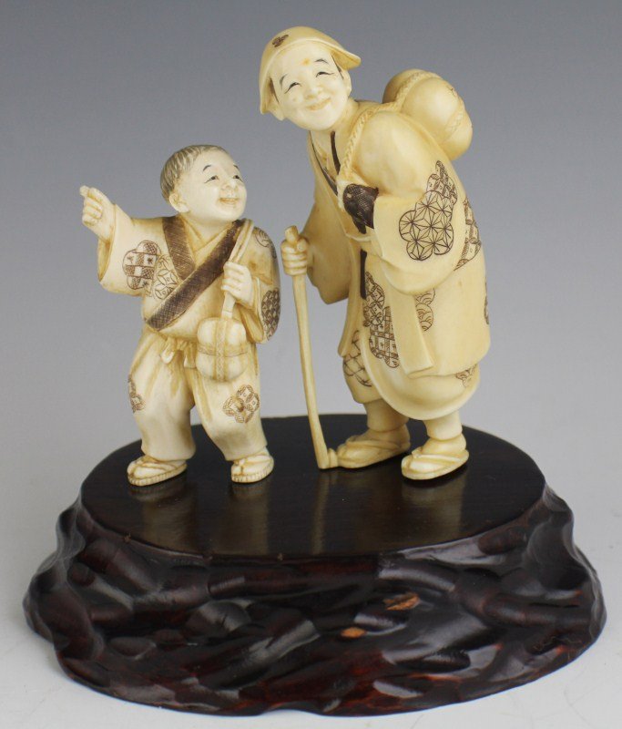 TWO CARVED IVORY OKIMONO PEASANT FATHER AND SON: TWO CARVED IVORY OKIMONO PEASANT FATHER AND SON Two Japanese carved ivory Okimono figures, father and son, both working class. Figures are wearing kimono or yukata and geta. Figures attach to wooden b
