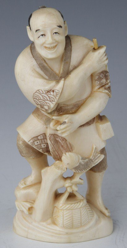 JAPANESE CARVED IVORY FISHERMAN OKIMONO SIGNED: JAPANESE CARVED IVORY FISHERMAN OKIMONO SIGNED Carved ivory Japanese fisherman with etched and stained designs. Posed with right leg propped up on a rock. Fisherman's basket and a fish are at his feet
