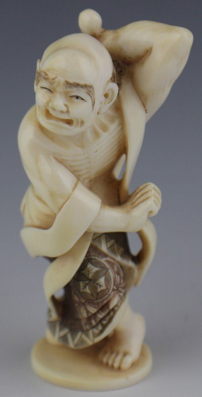 CARVED IVORY CONTORTED LARGE NETSUKE SIGNED: CARVED IVORY CONTORTED LARGE NETSUKE SIGNED A oversized carved ivory netsuke of a Japanese male half clothed in delicately etched and stained robes. Body and visage are contorted in his strained effor