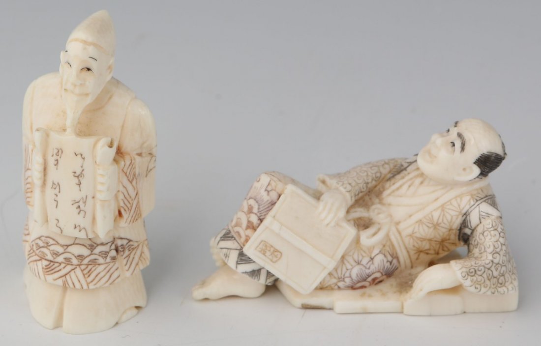 TWO JAPANESE CARVED IVORY NETSUKES: TWO JAPANESE CARVED IVORY NETSUKES A man holding a scroll, standing. Another reclining, contemplating his book. Both signed by the artists. Size: 2" **Please be advised: International shipping it NOT 