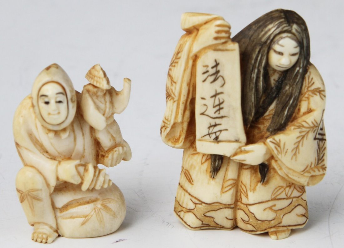 TWO CARVED IVORY NETSUKE TURN FACE AND DANCER: TWO CARVED IVORY NETSUKE TURN FACE AND DANCER Two carved ivory netsuke. One is in the form of a mask dancer in kimono, displaying a scroll with symbols, and long etched and stained hair. The other is 