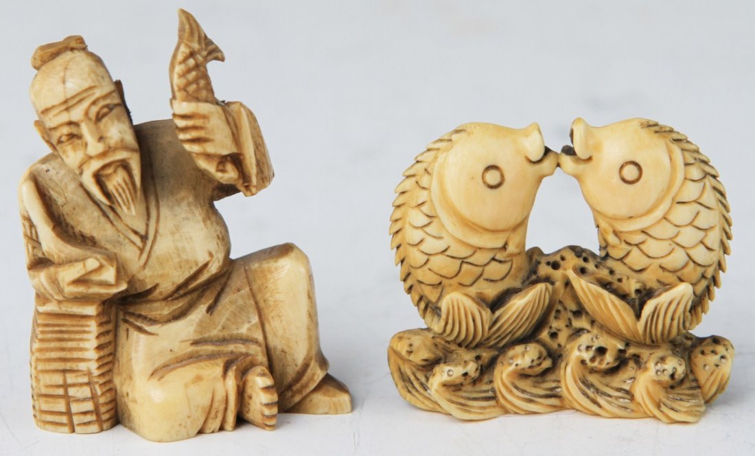 TWO CARVED IVORY FISH NETSUKE: TWO CARVED IVORY FISH NETSUKE Two carved ivory netsuke, fish motif. A fisherman, lounging on his basket, displays fish in both hands. A pair of leaping fish, meet in mid air. Both signed to base. Size