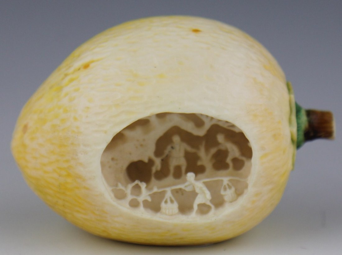 CARVED IVORY LEMON VILLAGE SCENE SIGNED: CARVED IVORY LEMON VILLAGE SCENE SIGNED A ivory carving in the style of clam shell village scenes, in this case however taking place in a lemon. The side of the lemon has been opened to reveal three m