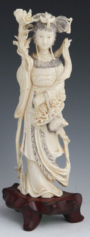 CHINESE IVORY FEMALE FIGURE HOLDING FLOWERS: CHINESE IVORY FEMALE FIGURE HOLDING FLOWERS Ivory female figure holding flowers in one hand and a basket in the other standing on a 1.1" rosewood stand. Size: 8.1" **Please be advised: International s