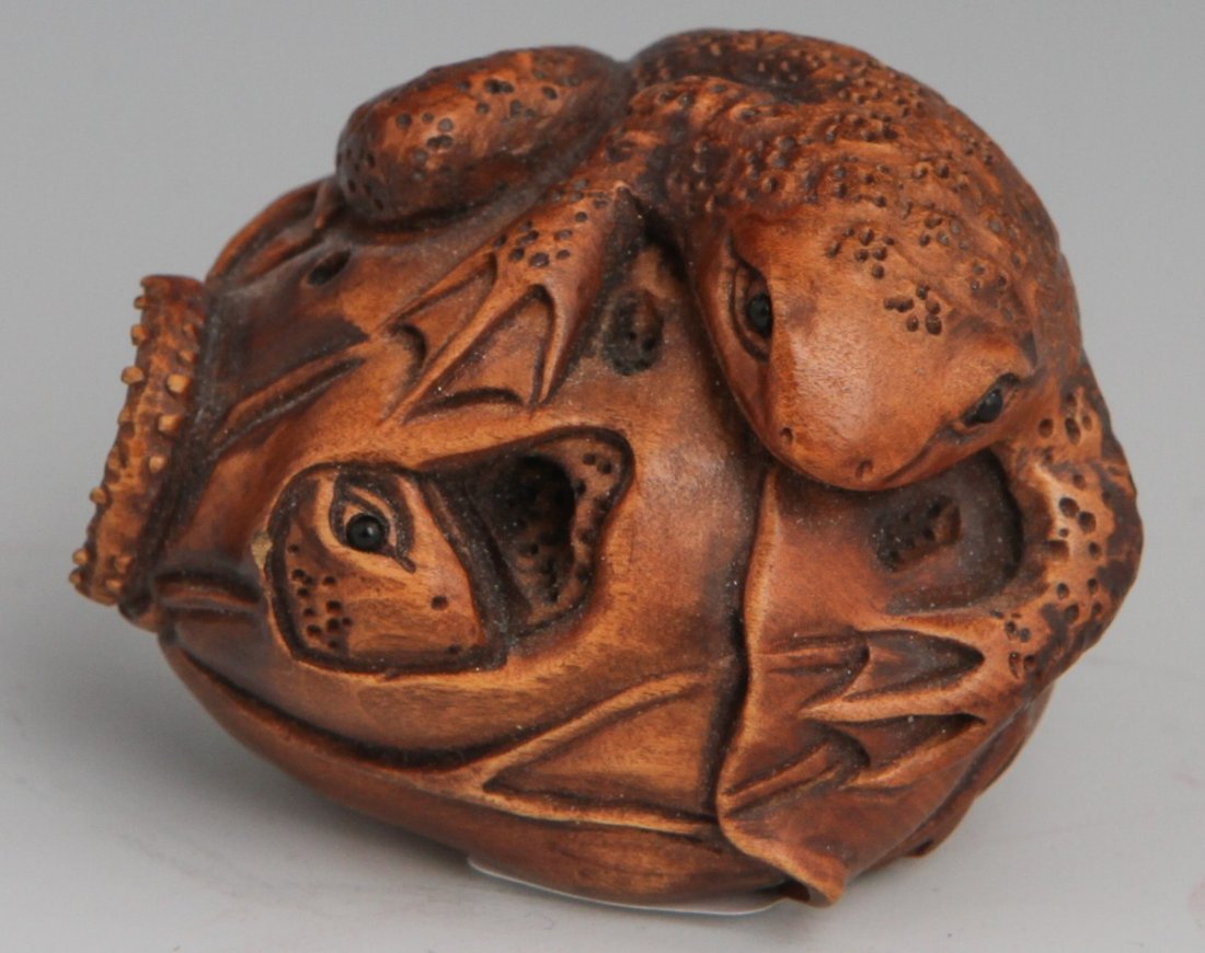 FINE CARVED BOXWOOD NETSUKE SIGNED: FINE CARVED BOXWOOD NETSUKE SIGNED A carved boxwood netsuke of a pair of frogs, one recumbent atop a vegetable, the other hidden within the same vegetable, head partially exposed. Inlaid glass bead ey