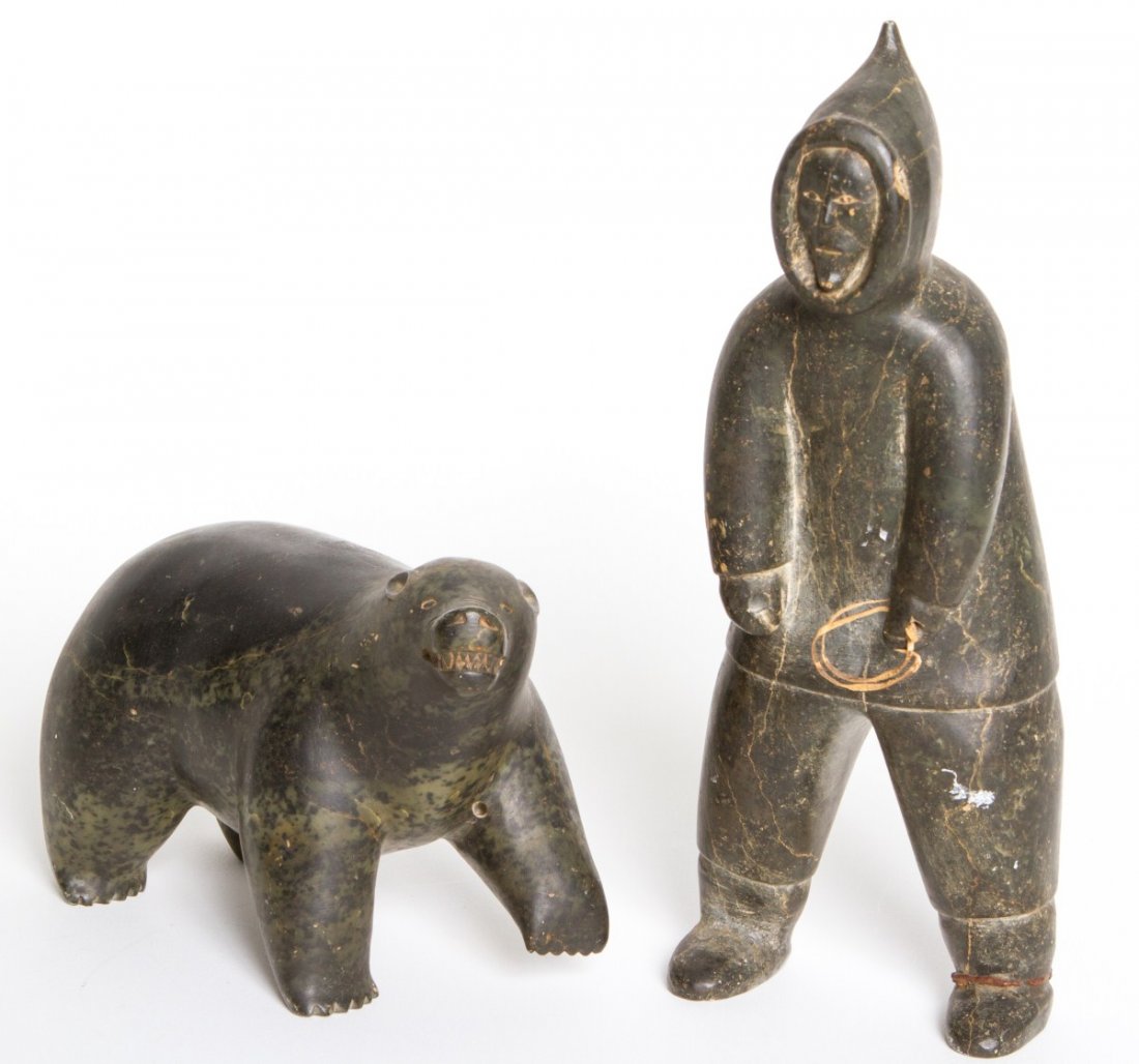 TWO INUIT STONE CARVINGS BEAR AND MAN SIGNED: TWO INUIT STONE CARVINGS BEAR AND MAN SIGNED Two carved Inuit figures in black and mottled green stone: a slightly hunched standing male in full cold weather gear clutching a rope and a snarling bear,