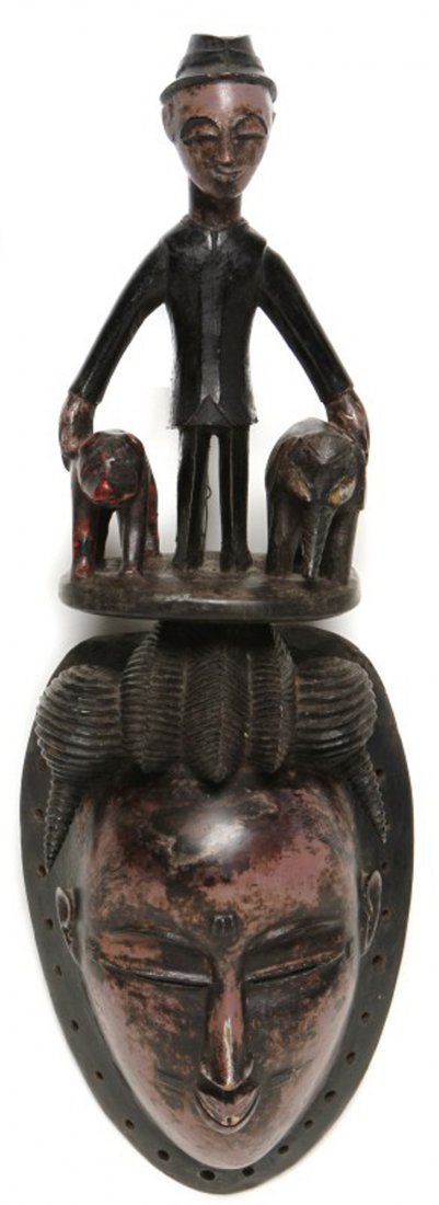 WOODEN AFRICAN GURO MASK: WOODEN AFRICAN GURO MASK An African Guro mask. Man walking with elephant and bear atop of hair. Has wire for hanging. Size: 19 x 6 x 3"