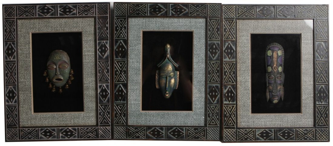 THREE FRAMED AFRICAN TRIBAL MASKS: THREE FRAMED AFRICAN TRIBAL MASKS A lot of three framed African carved wooden masks, framed in shadow boxes. All framed in carved black wooden frames with gray-blue matting. Size: 14 x 18" (framed)