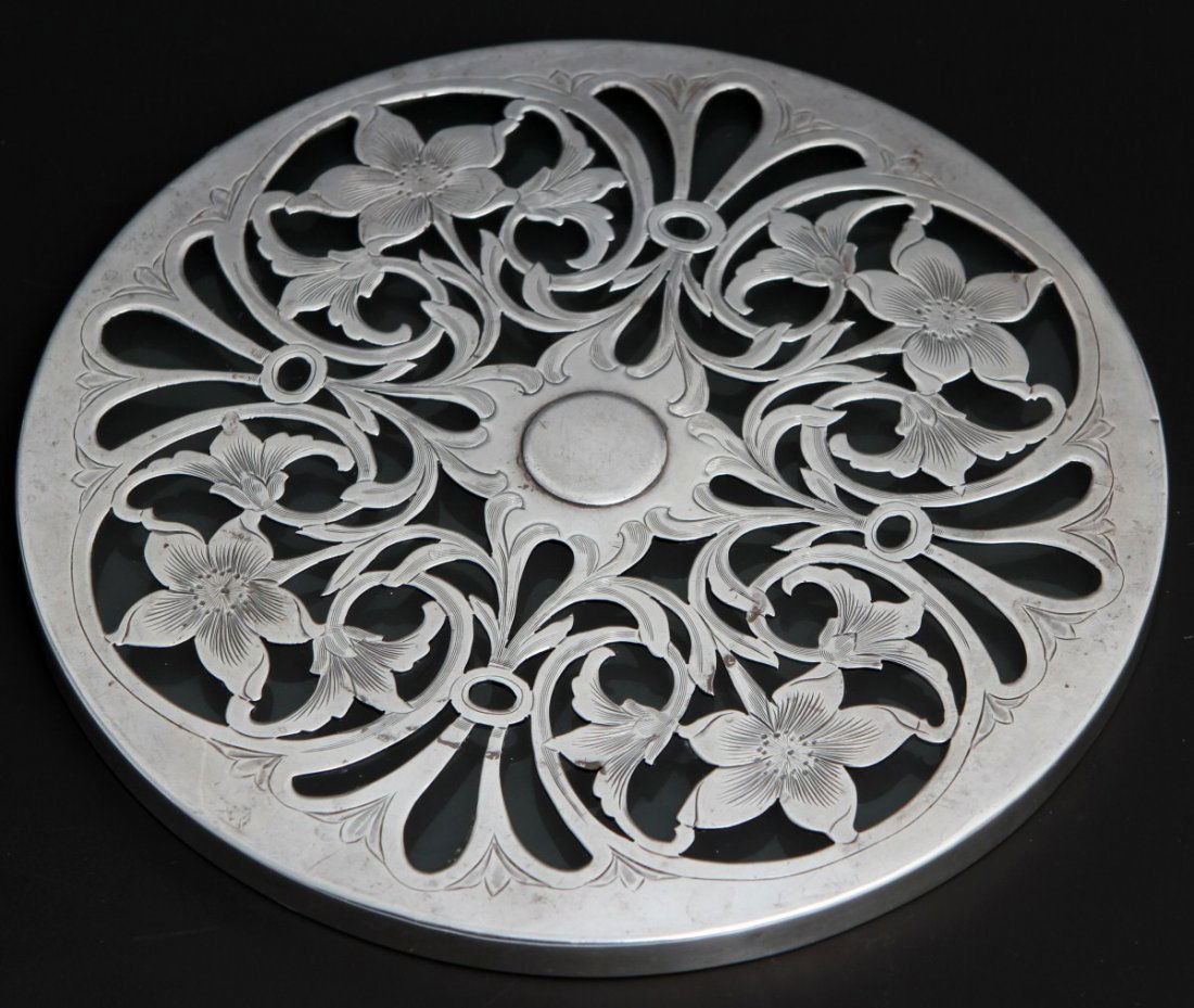 MADE FOR TIFFANY & CO STERLING AND GLASS TRIVET: MADE FOR TIFFANY & CO STERLING AND GLASS TRIVET Made for Tiffany & Co sterling over glass trivet. Pierced floral design sterling set over and bezelled around a glass disc. Marked "Made for Tiffany & C