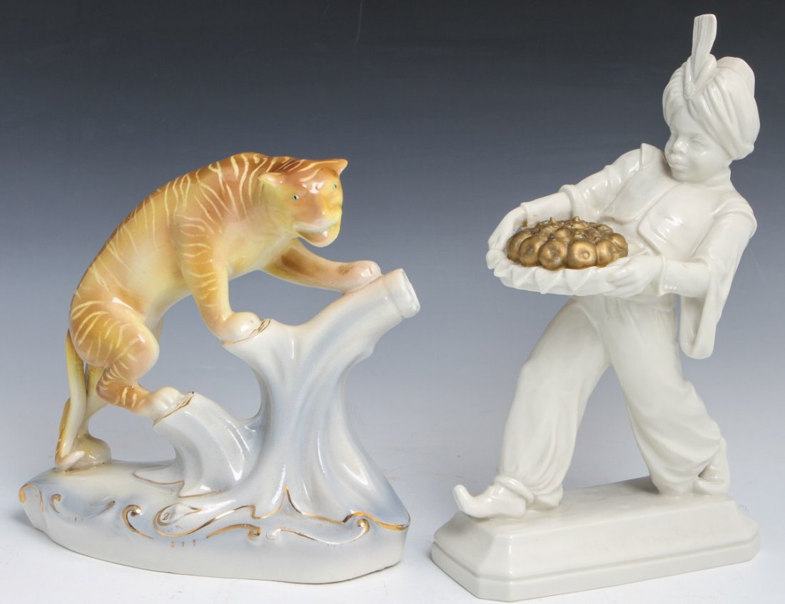 VINTAGE PORCELAIN STATUES OF MOHR AND TIGER: VINTAGE PORCELAIN STATUES OF MOHR AND TIGER Lot of two vintage porcelain figurines. Early 20th century Unterweissbach of Mohr carrying a basket of golden fruit, 11 1/2"h, Marked #182 and Tiger climbin