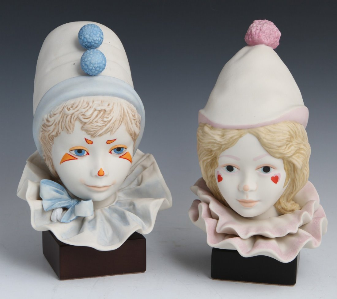 LOT OF 2 CYBIS PORCELAIN BOY AND GIRL CLOWN HEADS: LOT OF 2 CYBIS PORCELAIN BOY AND GIRL CLOWN HEADS Two porcelain clown head figurines by Cybis, one boy and one girl. Girl clown has pink hat and collar, with heart designs on her face. Boy clown has b