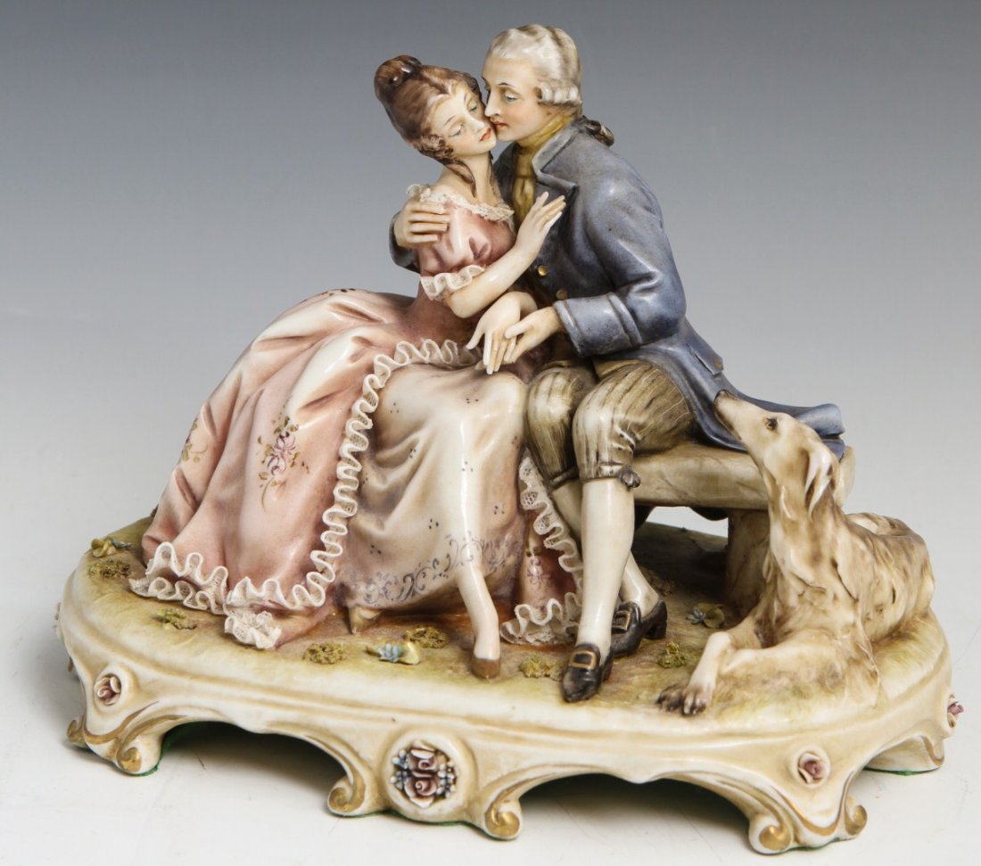 BORSATO ROMANTIC COUPLE SIGNED PORCELAIN FIGURE: BORSATO ROMANTIC COUPLE SIGNED PORCELAIN FIGURE Porcelain figure by Antonio Borsato, made in Italy. The Romantic Couple, #767. A romantic couple sitting on a bench with an Irish wolfhound at their sid