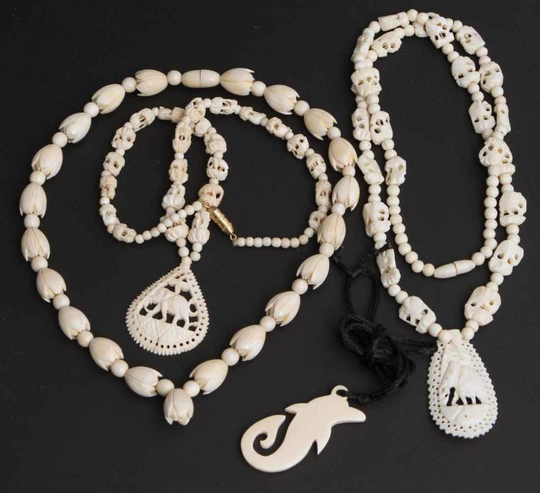 LOT OF 4 IVORY NECKLACES: LOT OF 4 IVORY NECKLACES Lot includes 2 necklaces with carved elephants beads and pendants, 1 lotus bud choker, and an ivory dolphin pendant on a black fabric cord. Size: 17"-27" Weight: 105.4g
