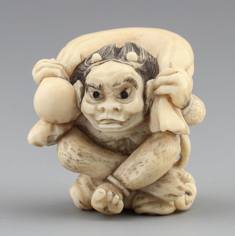 JAPANESE CARVED IVORY NETSUKE FUJIN WITH BAG OF WIND: JAPANESE CARVED IVORY NETSUKE FUJIN WITH BAG OF WIND Carved ivory Japanese netsuke of Fujin, the god of wind with his bag of wind. Signed. Size: 1.25 x 1.25 x 1" Weight: 27g