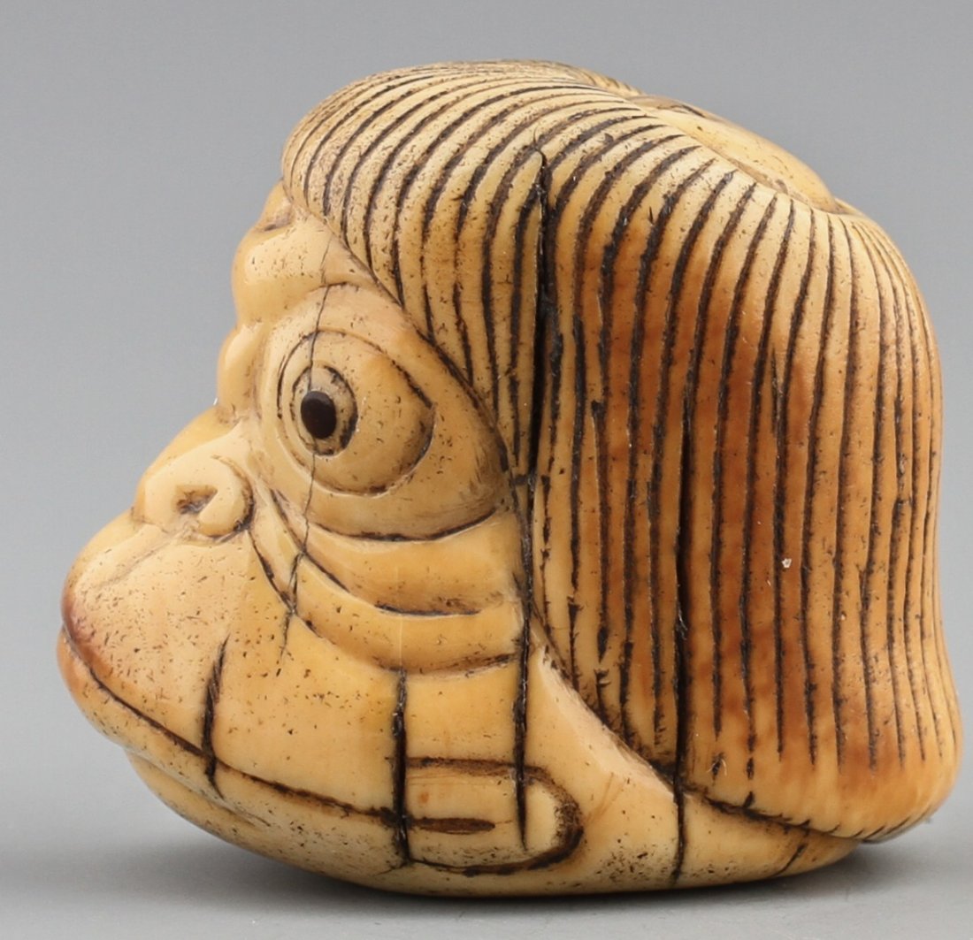 JAPANESE CARVED IVORY NETSUKE KAPPA: JAPANESE CARVED IVORY NETSUKE KAPPA Japanese ivory carved netsuke of a Kappa head, mottled patina with some age cracks, Signed. Size: 1 3/8"h Weight: 36g