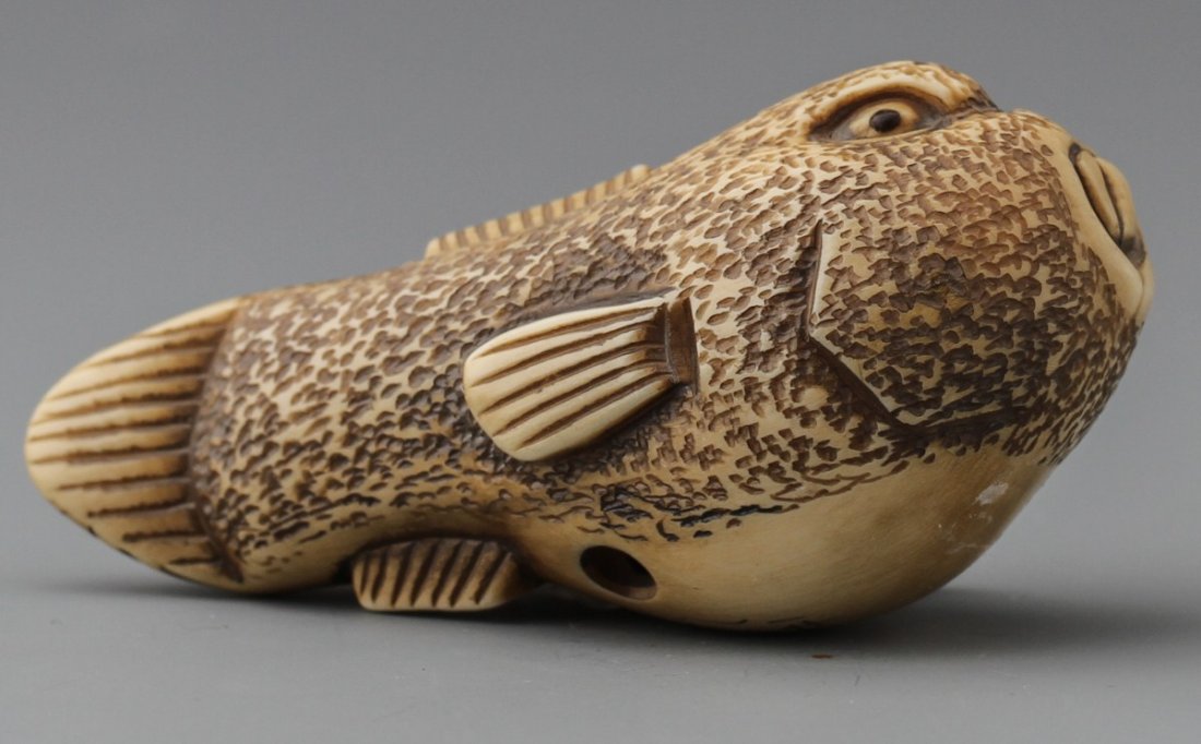 JAPANESE CARVED IVORY PUFFERFISH BAISHO: JAPANESE CARVED IVORY NETSUKE PUFFERFISH BAISHO Early 20th century Japanese ivory carved netsuke of bloated pufferfish, signed Baisho. Size: 2 5/8"l Weight: 38g