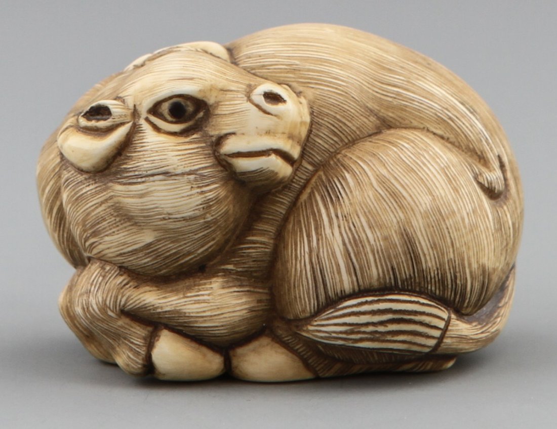 JAPANESE CARVED IVORY NETSUKE RECUMBENT OX BAISHO: JAPANESE CARVED IVORY NETSUKE RECUMBENT OX BAISHO Early 19th century Japanese carved ivory netsuke of a recumbent ox. Monochromed details with some age cracks, Signed Baisho. Size: 1.6 x 1.25" Weight: