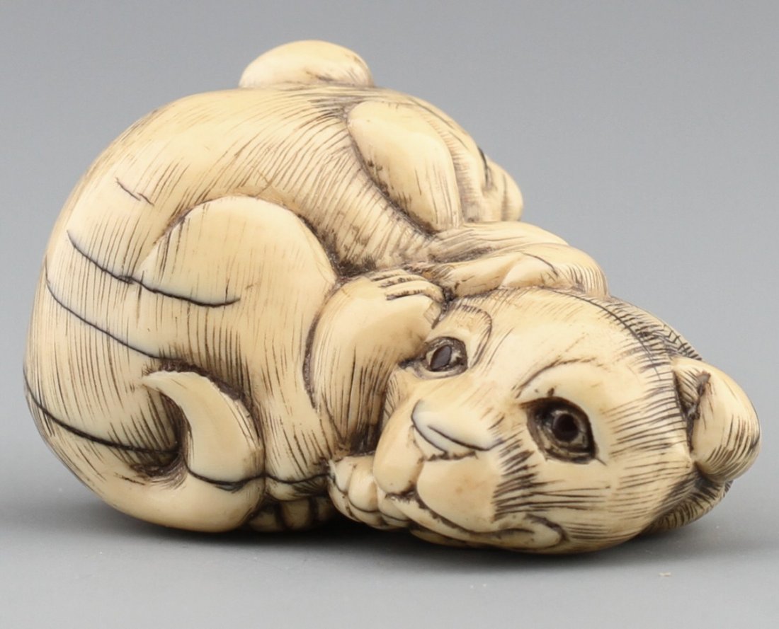 JAPANESE CARVED IVORY NETSUKE DOGS KUNIMASA: JAPANESE CARVED IVORY NETSUKE DOGS KUNIMASA Japanese carved ivory netsuke figure of two dogs. Signed, Kunimasa, 19th century. Size: 1.5 x 1.25 x 1" Weight: 28.4g