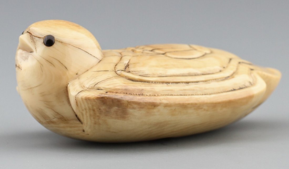 JAPANESE CARVED IVORY NETSUKE SONGBIRD: JAPANESE CARVED IVORY NETSUKE SONGBIRD Japanese carved ivory netsuke of stylized songbird with a fan/ traditional geisha hairpiece motif on it's back. Some age cracks, Signed. Size: 2 5/8"l Weight: 63