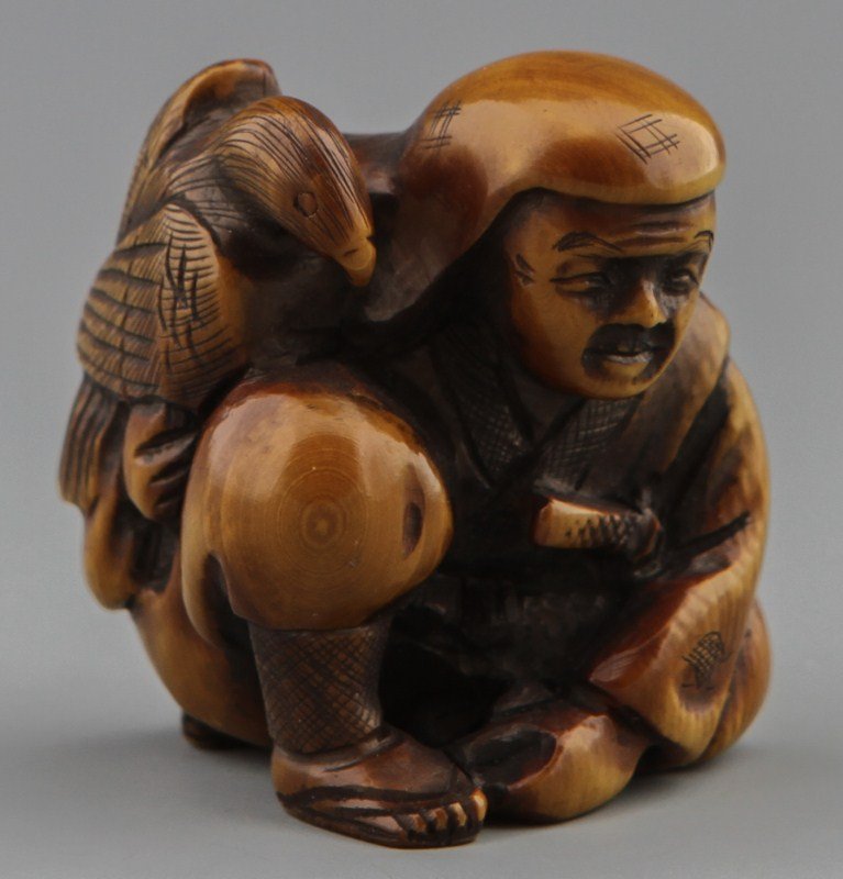JAPANESE CARVED IVORY NETSUKE ELDER WITH EAGLE: JAPANESE CARVED IVORY NETSUKE ELDER WITH EAGLE Japanese carved ivory netsuke figure of a elder wearing traditional garb with eagle perched on shoulder, Signed. Size: 1 3/4 x 1 3/4" Weight: 42.8 g