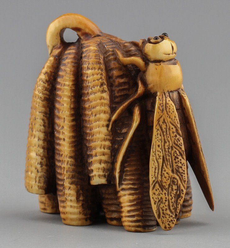 JAPANESE CARVED IVORY NETSUKE WASP AND NEST: JAPANESE CARVED IVORY NETSUKE WASP AND NEST Japanese carved ivory netsuke figure of wasp clinging to nest with even patina, Signed. Size: 1 1/2"h Weight: 23g