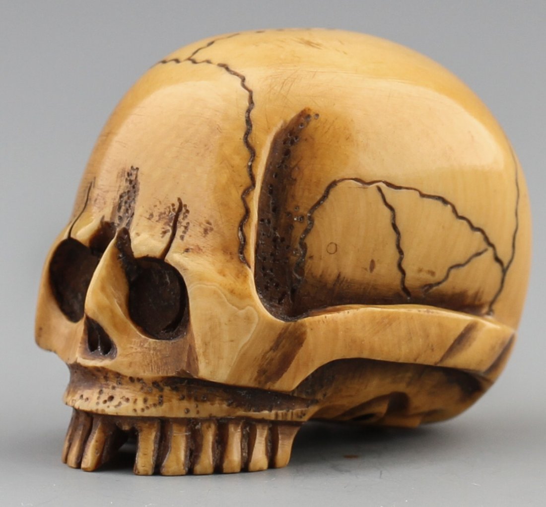 JAPANESE CARVED IVORY NETSUKE SKULL: JAPANESE CARVED IVORY NETSUKE SKULL Japanese carved ivory netsuke figure of a skull. No signature. Size: 1.5 x 1.25 x 1.25" Weight: 35g