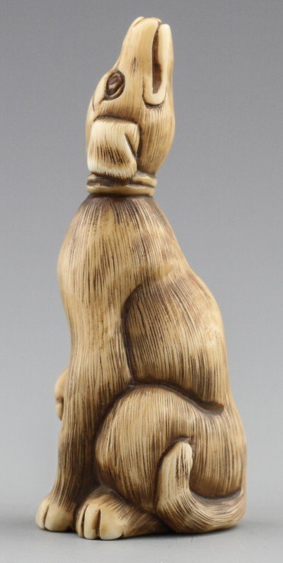 JAPANESE CARVED IVORY NETSUKE DOG: JAPANESE CARVED IVORY NETSUKE DOG Japanese carved ivory netsuke figure of dog looking up. Signed. Monochrome. Size: 2.5 x .75 x 1" Weight: 16.8g