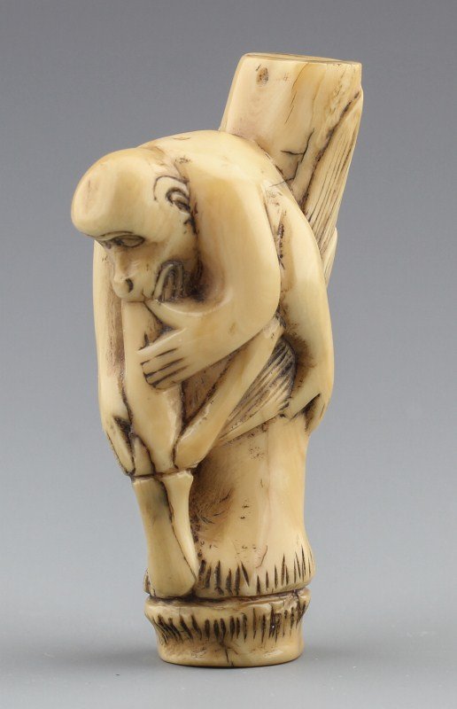 JAPANESE CARVED IVORY NETSUKE BAMBOO APE: JAPANESE CARVED IVORY NETSUKE BAMBOO APE Japanese carved netsuke ape riding on bamboo shoot. Front of bamboo has small cracks and is signed on base. Size: 1 X 2 3/4 Weight: 36.3 G