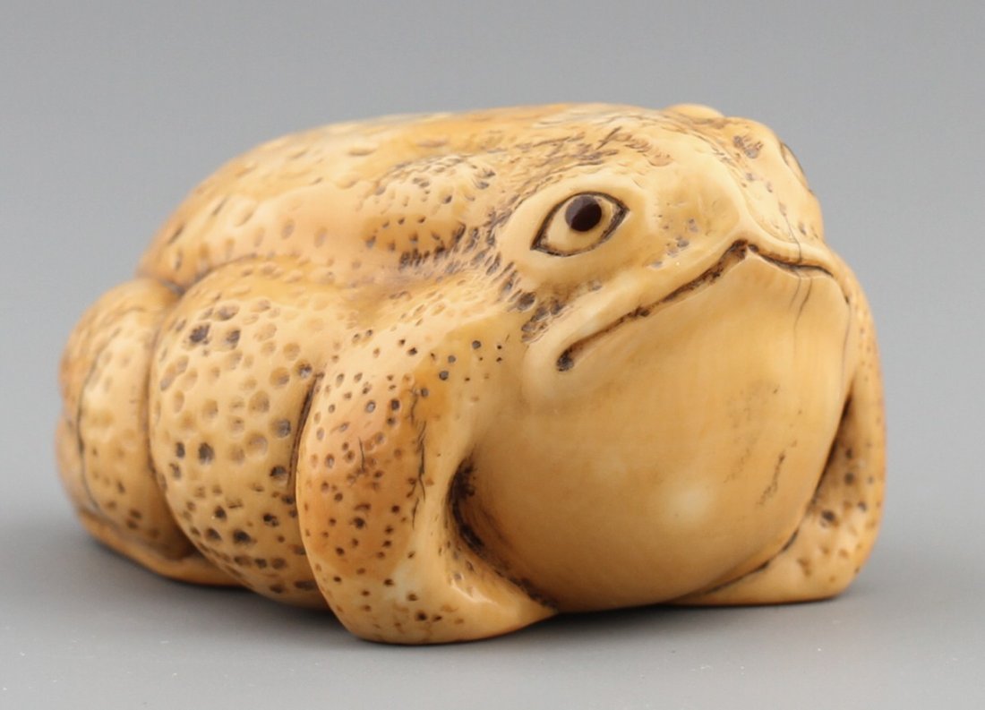 JAPANESE CARVED IVORY NETSUKE BULL FROG: JAPANESE CARVED IVORY NETSUKE BULL FROG Japanese carved ivory netsuke of a bull frog. Very good detail and signed. Size: 1 1/2 x 1 3/4" Weight: 33.1 g