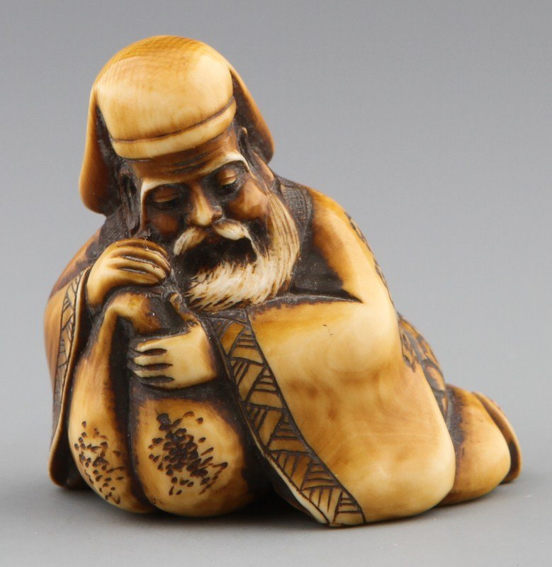 JAPANESE CARVED IVORY NETSUKE FIGURE OF MAN: JAPANESE CARVED IVORY NETSUKE FIGURE OF MAN Japanese carved ivory netsuke figure of seated man with a sack. Signed. Stained. Size: 2 x 1.25 x 1" Weight: 37g