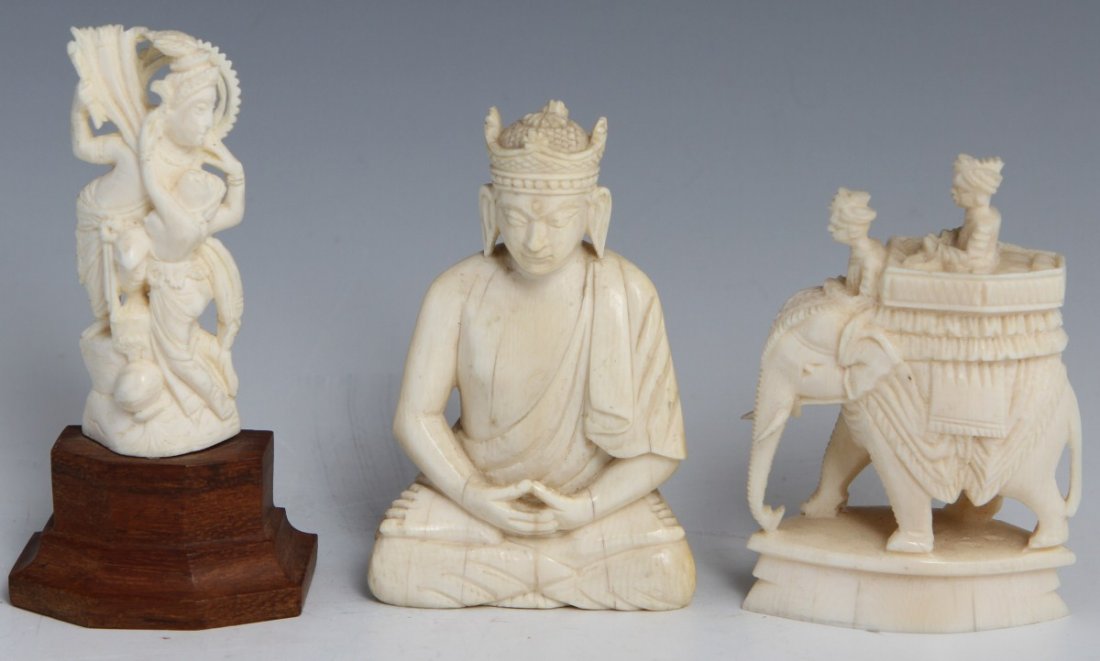 THREE INDIAN CARVED IVORY FIGURES: THREE INDIAN CARVED IVORY FIGURES Three carved ivory Southeast Asian figures, two mid 20th century pieces, one late 19th or early 20th. The latter is of a buddha seated in lotus position, hands intert