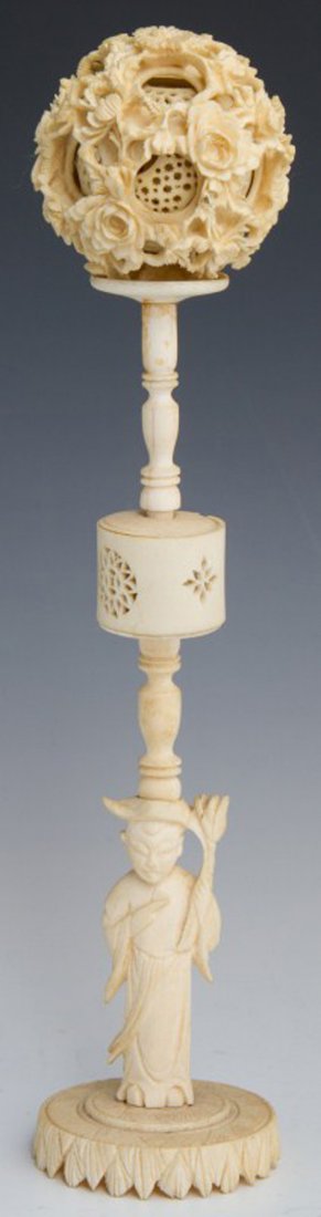 CHINESE IVORY FLORAL PUZZLE BALL W/ FIGURAL STAND: CHINESE IVORY FLORAL PUZZLE BALL W/ FIGURAL STAND Intricately carved Chinese ivory puzzle ball with stand. Ball has a floral motif and in good condition. The spinning element on stand is broken. Overa