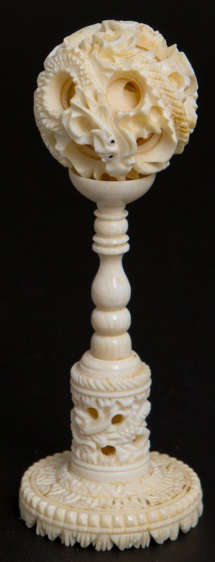 CHINESE CARVED IVORY PUZZLE BALL WITH STAND: CHINESE CARVED IVORY PUZZLE BALL WITH STAND Miniature Chinese carved ivory puzzle ball with stand, dragon motif ball and base. Size: Overall 4"h, Ball 1"d