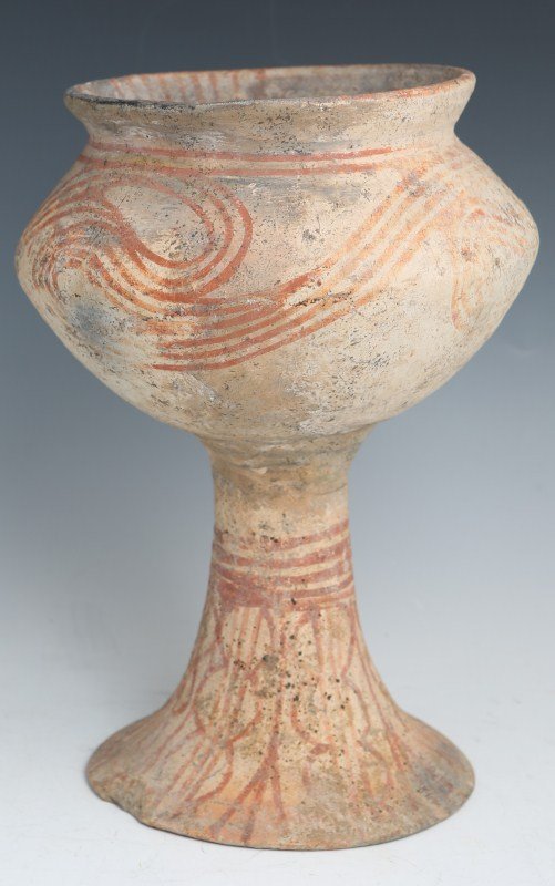 ANCIENT BAN CHIANG PAINTED FOOTED VESSEL: ANCIENT BAN CHIANG PAINTED FOOTED VESSEL Ancient Ban Chiang (Northern Thailand) Neolithic Period 1000-500 B.C. footed pottery vessel of globular form with flared rim and painted linear scrolling motif