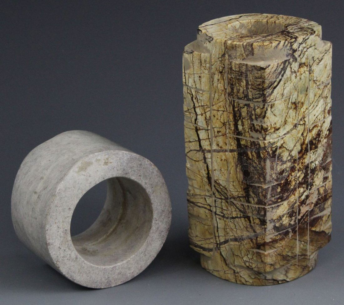 (2) FENG SHUI HARD STONE CONG CYLINDERS: (2) FENG SHUI HARD STONE CONG CYLINDERS A lot of two cong cylinders, hard stone, used in Feng Shui. Carved with surface decorations. Size: 5.5", 2" Weight: 1344g