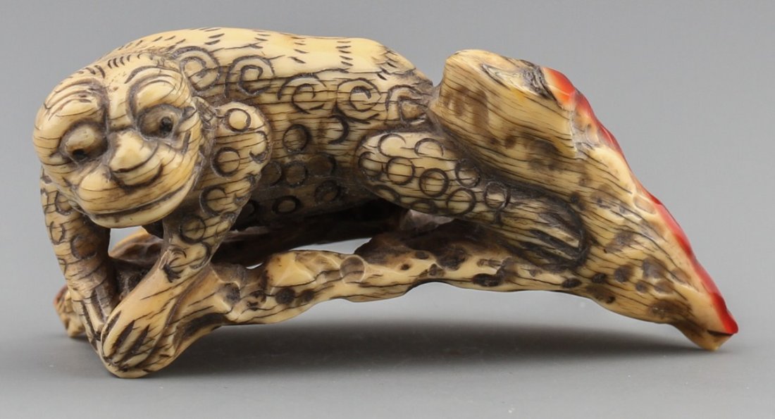 JAPANESE CARVED IVORY OKIMONO FOO DOG ON TREE