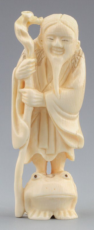 JAPANESE CARVED IVORY NETSUKE OLD MAN AND FROG: JAPANESE CARVED IVORY NETSUKE OLD MAN AND FROG Japanese carved ivory netsuke of man in traditional Japanese garb and staff on standing on frog. Figure signed. Size: 3 x 1" Weight: 40.3g
