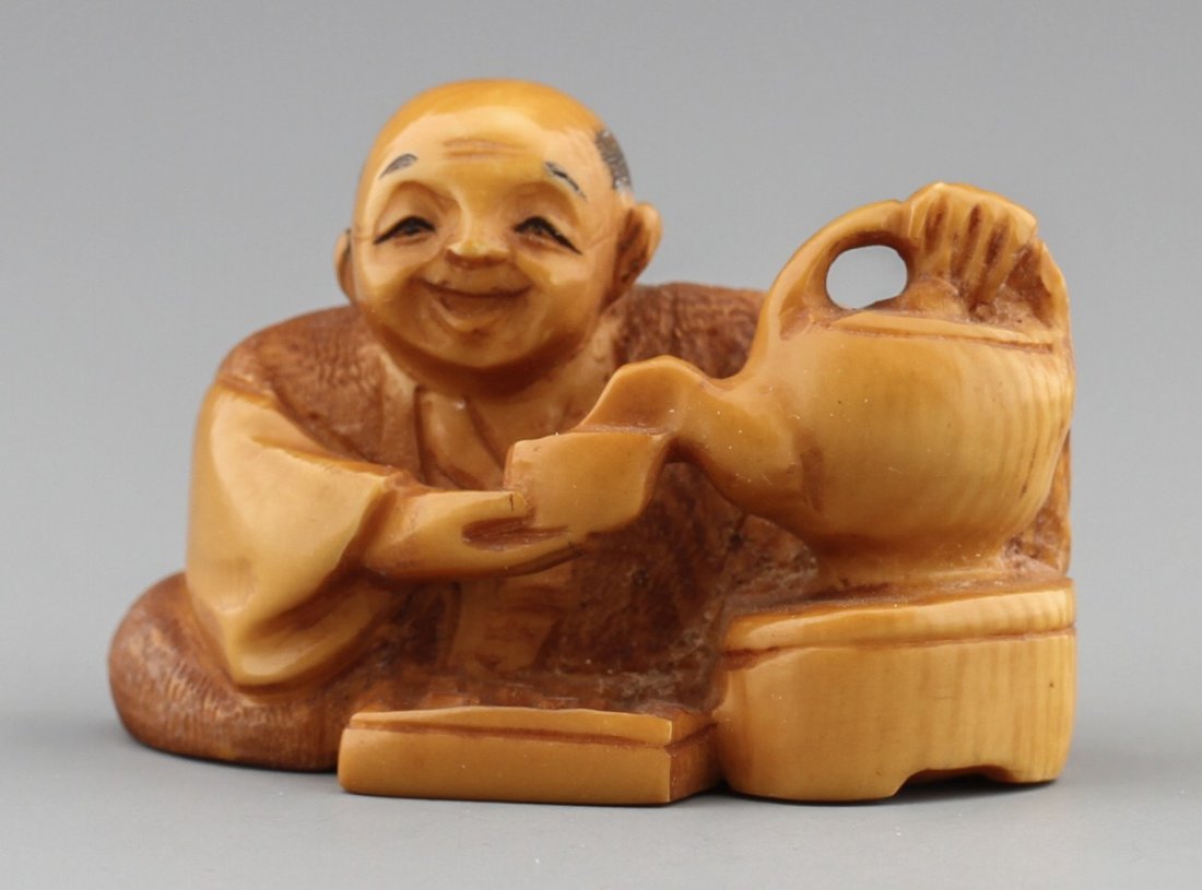 JAPANESE CARVED IVORY NETSUKE ELDER POURING TEA