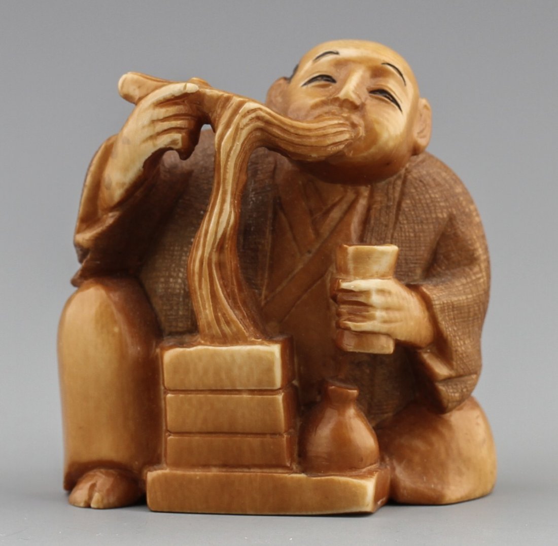 JAPANESE CARVED IVORY NETSUKE ELDER WITH FOOD: JAPANESE CARVED IVORY NETSUKE ELDER WITH FOOD Japanese carved ivory netsuke figure of a elderly man eating noodles and drinking. Signed. Size: 2 x 1.5" Weight: 42.3g
