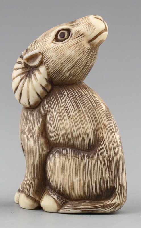 JAPANESE CARVED IVORY NETSUKE OF RAM: JAPANESE CARVED IVORY NETSUKE OF RAM Japanese carved ivory netsuke of sitting ram, Signed Baisho. Size: 1.75" Weight: 19g