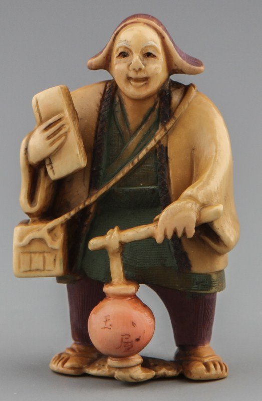 JAPANESE CARVED IVORY NETSUKE OF WOMAN WITH BOOKS