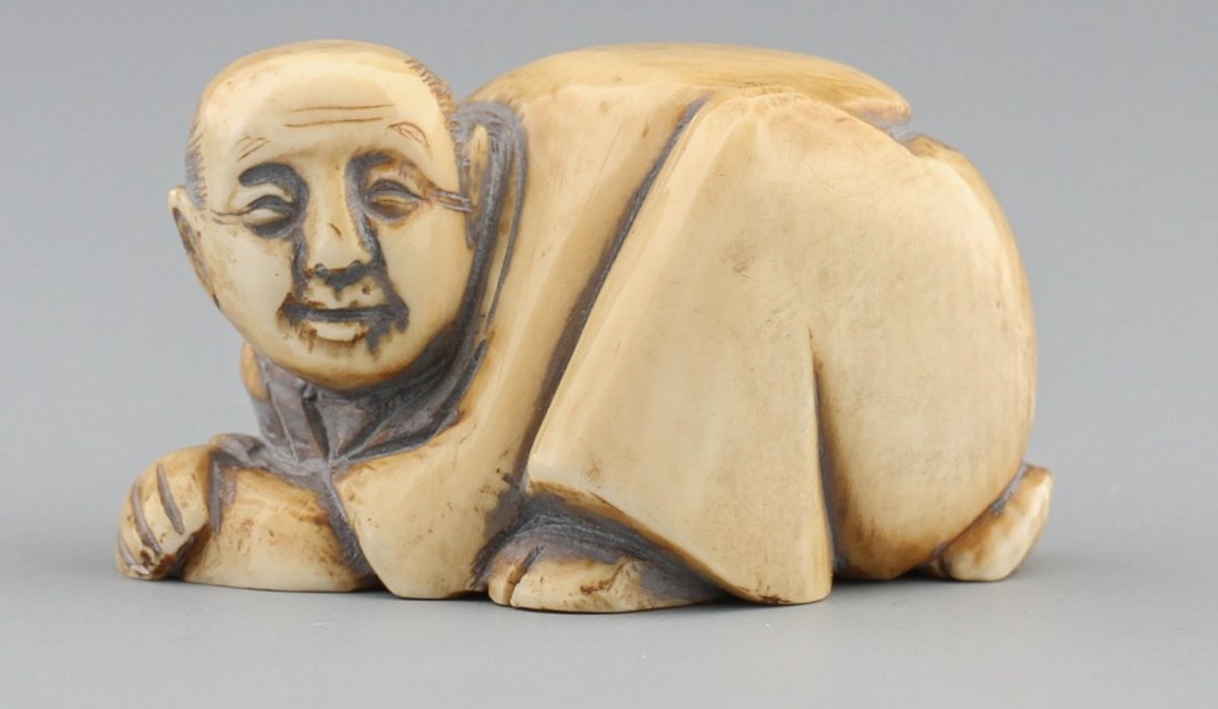 JAPANESE CARVED IVORY NETSUKE OF MAN CRAWLING