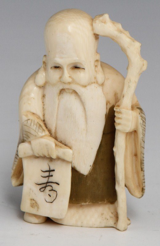 JAPANESE CARVED IVORY NETSUKE OF IMMORTAL: JAPANESE CARVED IVORY NETSUKE OF IMMORTAL Japanese carved ivory netsuke of Fukurokuju holding his staff and an inscribed scroll. Monochromed detail, Signed. Size: 2" Weight: 27g