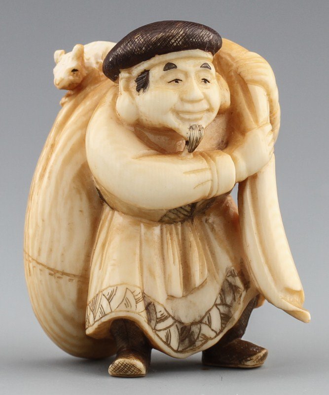 JAPANESE CARVED IVORY NETSUKE DAIKOKU: JAPANESE CARVED IVORY NETSUKE DAIKOKU Japanese carved ivory netsuke figure, Daikoku of the Shichi Fukujin, or seven lucky gods, monochrome. Pictured with his bag of rice and a rat. Signed. Size: 2 x 1