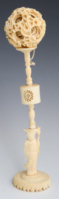 CHINESE IVORY DRAGON PUZZLE BALL W/ FIGURAL STAND: CHINESE IVORY DRAGON PUZZLE BALL W/ FIGURAL STAND Intricately carved Chinese ivory puzzle ball with stand. Ball has a dragon motif and the stand can be unscrewed just above figure's head. Overall heig